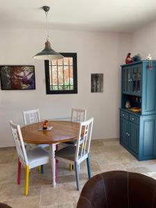 une table à manger avec des chaises et un meuble bleu dans l'établissement gîte de Jo et Chantal, à Belgentier