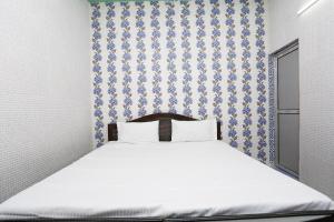 Schlafzimmer mit einem Bett mit einer blauen und weißen Tapete in der Unterkunft SPOT ON Hotel Doon Sabri in Roorkee