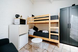a small room with bunk beds and a refrigerator at Logies by Suzan in Hasselt