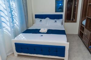 a blue and white bed in a room at Pearl Suites and Hospitality in Bungoma