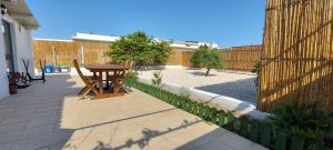 a patio with a wooden table and a fence at Casa da Gino in Calasetta