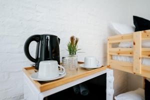 a black kettle and two cups on a wooden shelf at Logies by Suzan in Hasselt