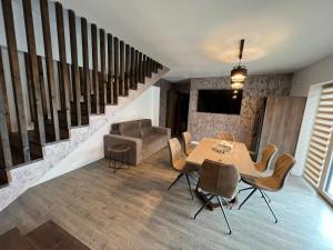 Un comedor con mesa y sillas y una escalera. en Kul House - Cazare, en Băileşti 13 fotos más