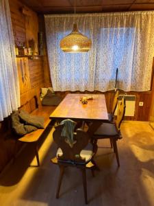 a dining room with a table and chairs and a light at Chata na léto in Nespeky