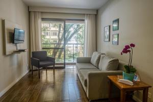 uma sala de estar com um sofá e uma televisão em Travel Inn Park Avenue Jardins em São Paulo