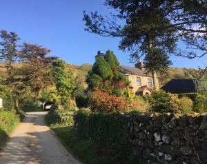 a road leading to a house with a stone wall at Self Catering Cottage in Talsarnau