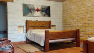 a bedroom with a bed and a painting on the wall at Risgua in Tinjacá