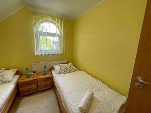 a bedroom with two beds and a window at Bodzás vendégház - Bodza u.4. in Kiskunmajsa
