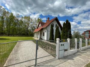 una cerca blanca frente a una casa en Bodzás vendégház - Bodza u.4., en Kiskunmajsa