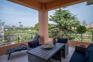 a patio with a table and chairs on a balcony at Helen Sweet Home in Kounoupidhianá