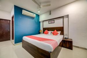 1 dormitorio con 1 cama grande con almohadas rojas en OYO Hotel Meredian Orchid Near Birla Mandir en Hyderabad