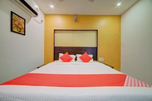 1 dormitorio con 1 cama grande con almohadas rojas en OYO Hotel Meredian Orchid Near Birla Mandir en Hyderabad