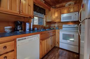 una cocina con electrodomésticos blancos y armarios de madera en Bearview Heights #244, en Townsend