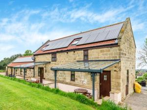 an old stone barn with solar panels on the roof at The Cottage - Uk43952 in Boosbeck