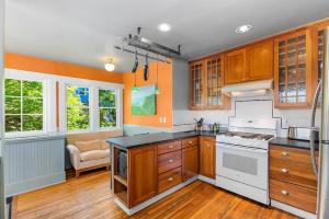 una cocina con armarios de madera y electrodomésticos blancos en Enchanted Path to a Gardenscape - 92 Walkscore!, en Seattle