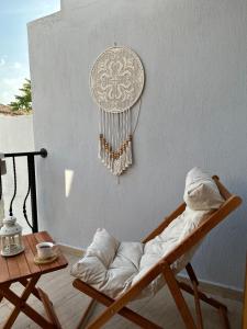 um quarto com uma cadeira e uma parede com um apanhador de sonhos em Hanole Guest House em Ayvalik