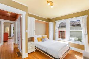 a bedroom with a white bed and a window at Enchanted Path to a Gardenscape - 92 Walkscore! in Seattle