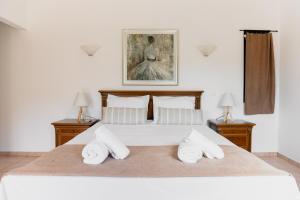 a bedroom with a large white bed with two lamps at Kouvelia Country Home Luxury Villa Rental in Nerotriviá +67 photos