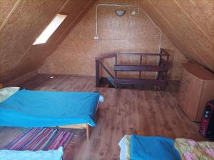 a attic room with two beds and a ladder at Domek z bala in Sejny