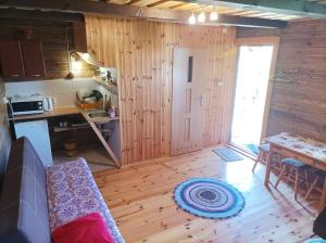 a room with a kitchen and a table and a door at Domek z bala in Sejny