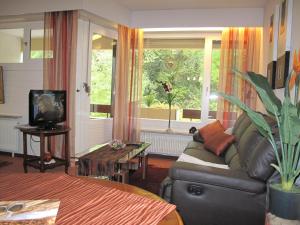 a living room with a couch and a large window at Appartementhaus im Grün in Bad Bellingen