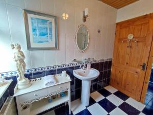 ein Bad mit einem Waschbecken und einem Spiegel in der Unterkunft Tower View Lodge in Ennis
