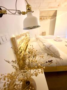 un tavolo con una lampada e un vaso con fiori di Stella Marina Luxury a Polignano a Mare
