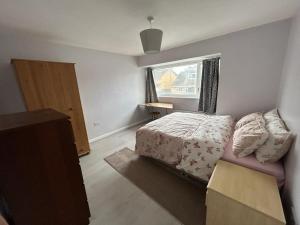 a small bedroom with a bed and a window at Ivydale Guest House in Syston