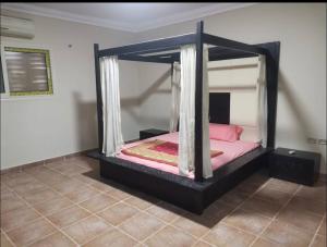 a bedroom with a black canopy bed with pink sheets at kaltala in Hurghada
