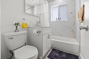 y baño blanco con aseo, bañera y lavamanos. en Comfy & Updated Apartment centrally located minutes away from everything!, en Miami