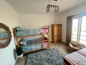 a bedroom with two bunk beds and a mirror at شاليه في امواج amwaj in El Alamein