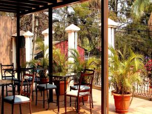 eine Terrasse mit Tischen, Stühlen und Topfpflanzen in der Unterkunft Apart-Hotel River View in Tegucigalpa