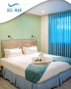 a bedroom with a large bed with blue curtains at Maxwell Del Mar Hotel in Christ Church
