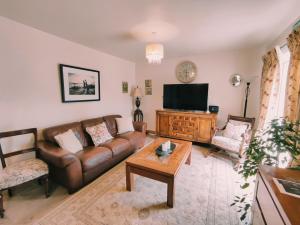 uma sala de estar com um sofá e uma televisão de ecrã plano em Tower View Lodge em Ennis