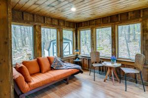 ein Wohnzimmer mit einem Sofa und einigen Fenstern in der Unterkunft Alpine Lake Resort Cabin Rental with Pool Access! in Terra Alta