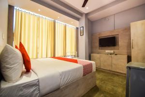 a hotel room with a bed and a television at Hotel Kanchan Residency in Kota