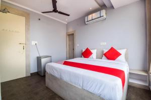 a bedroom with a large white bed with red pillows at Hotel Kanchan Residency in Kota
