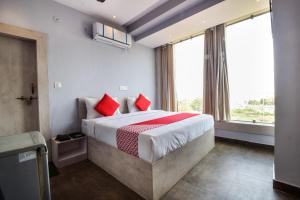 1 dormitorio con 1 cama grande con almohadas rojas en Hotel Kanchan Residency, en Kota