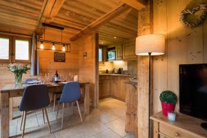 una cocina con armarios de madera, mesa y sillas en Le Mazot de Janton, en Combloux