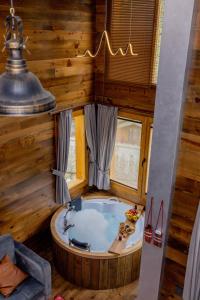 W drewnianym pokoju znajduje się łazienka z wanną. w obiekcie Safir Doğa Evleri w mieście Rize