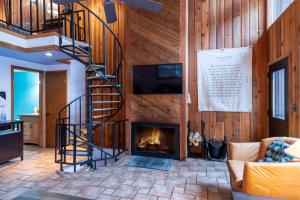 a living room with a staircase and a fireplace at Escape To Ptarmigan Village 100 in Whitefish