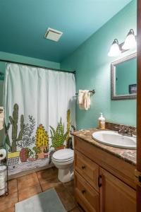 a bathroom with a shower curtain with a toilet and a sink at Escape To Ptarmigan Village 100 in Whitefish