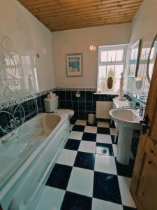 ein Badezimmer mit einer Badewanne und einem Waschbecken in der Unterkunft Tower View Lodge in Ennis