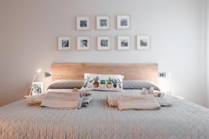 a bedroom with a large bed with pictures on the wall at Una Chicca in Valdobbiadene