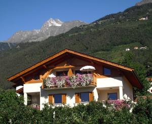 un bâtiment avec des fleurs dans une fenêtre dans l'établissement Törggelehof, à Lagundo