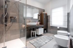 een badkamer met een wastafel, een toilet en een douche bij Una Chicca in Valdobbiadene