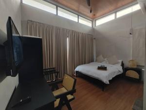 a bedroom with a bed and a tv in a room at Ocean Nadi 4 Bedrooms Beachfront Villa PD in Port Dickson