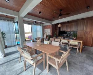 a dining room with a wooden table and chairs at Ocean Nadi 4 Bedrooms Beachfront Villa PD in Port Dickson