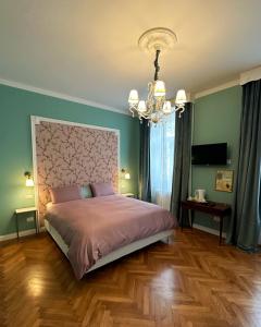 ein Schlafzimmer mit einem großen Bett und einem Kronleuchter in der Unterkunft A casa di Bruna in Gorizia