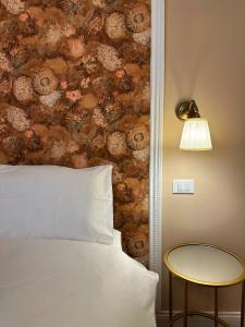 ein Schlafzimmer mit einem Bett, einem Tisch und einer Wand in der Unterkunft A casa di Bruna in Gorizia